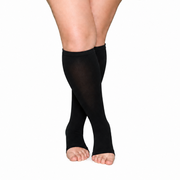 Black knee-high open-toe compression socks for wide calves, shown on crossed legs.